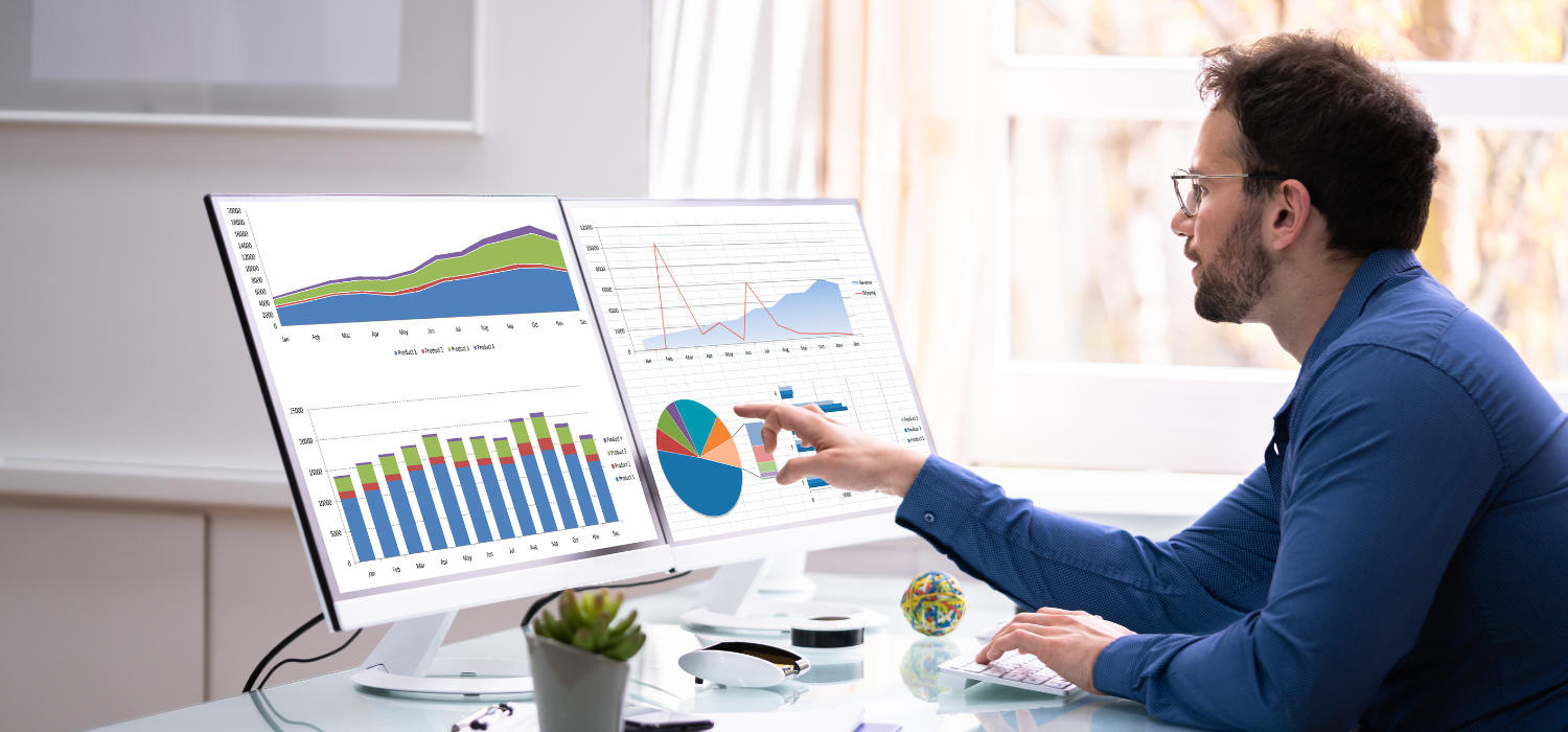 Seorang pria yang mengenakan kemeja formal biru dan berkacamata menganalisis analitik untuk memahami data besar dalamindustri perhotelan.