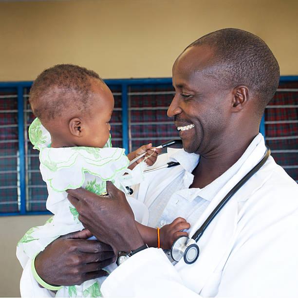 pediatrician holding baby (6-11 months) - doctor kenya stock pictures, royalty-free photos & images