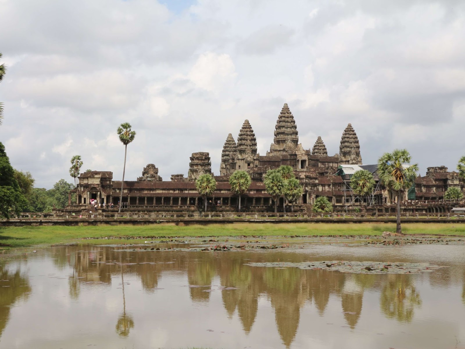 reasons to visit Angkor Wat. This is an image of Angkor Wat from one of the reflection ponds at noon.