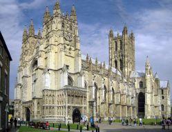 A large building with towers with Canterbury Cathedral in the background

Description automatically generated