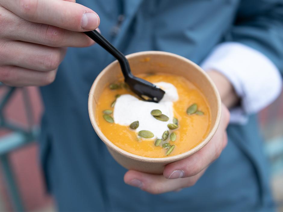 A person holding a bowl of butternut squash soup