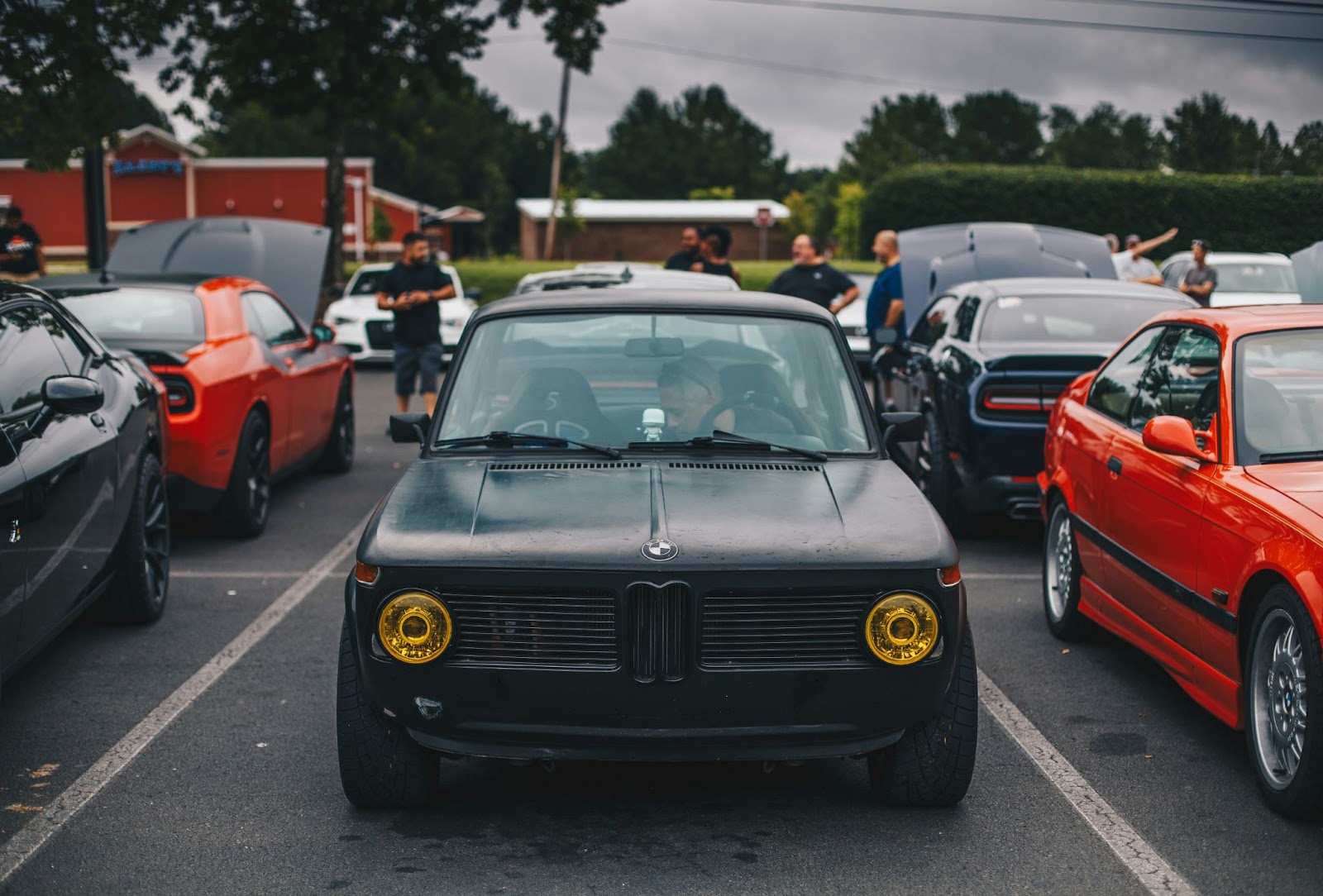 car owners standing around classic cars at a car show