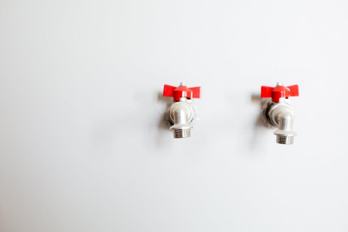 Free Faucets on White Wall Stock Photo