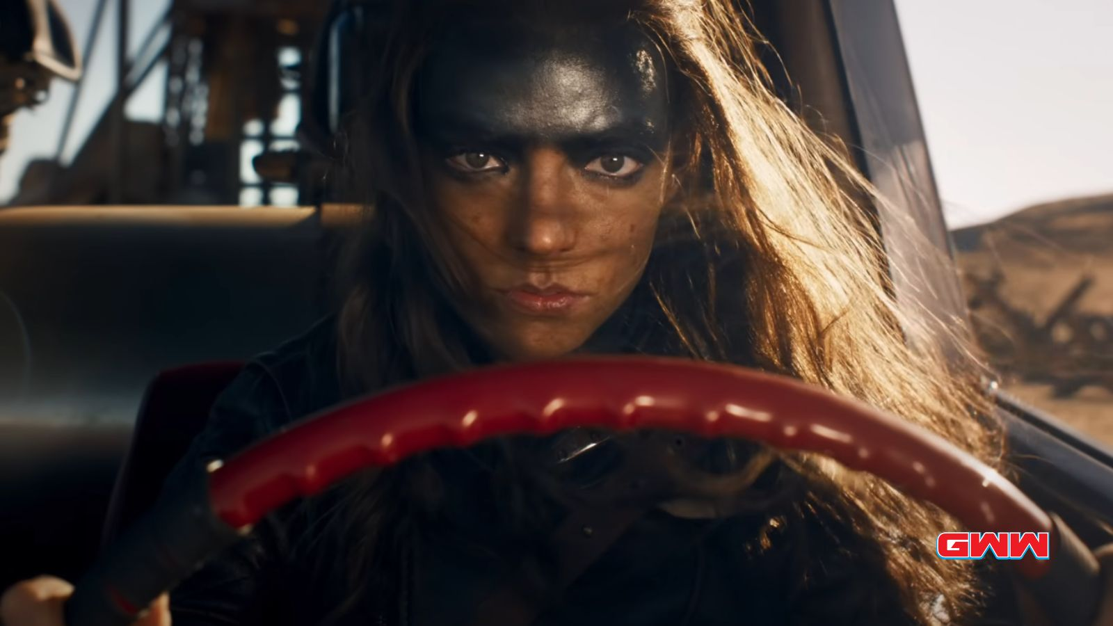 Woman with fierce makeup driving a car in sunlight.