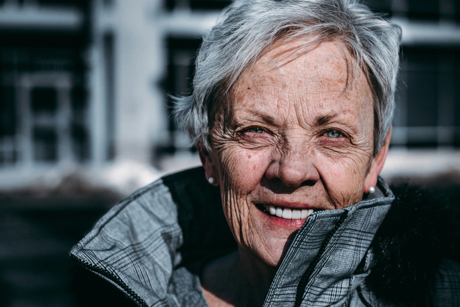 An older woman in a coat smiling