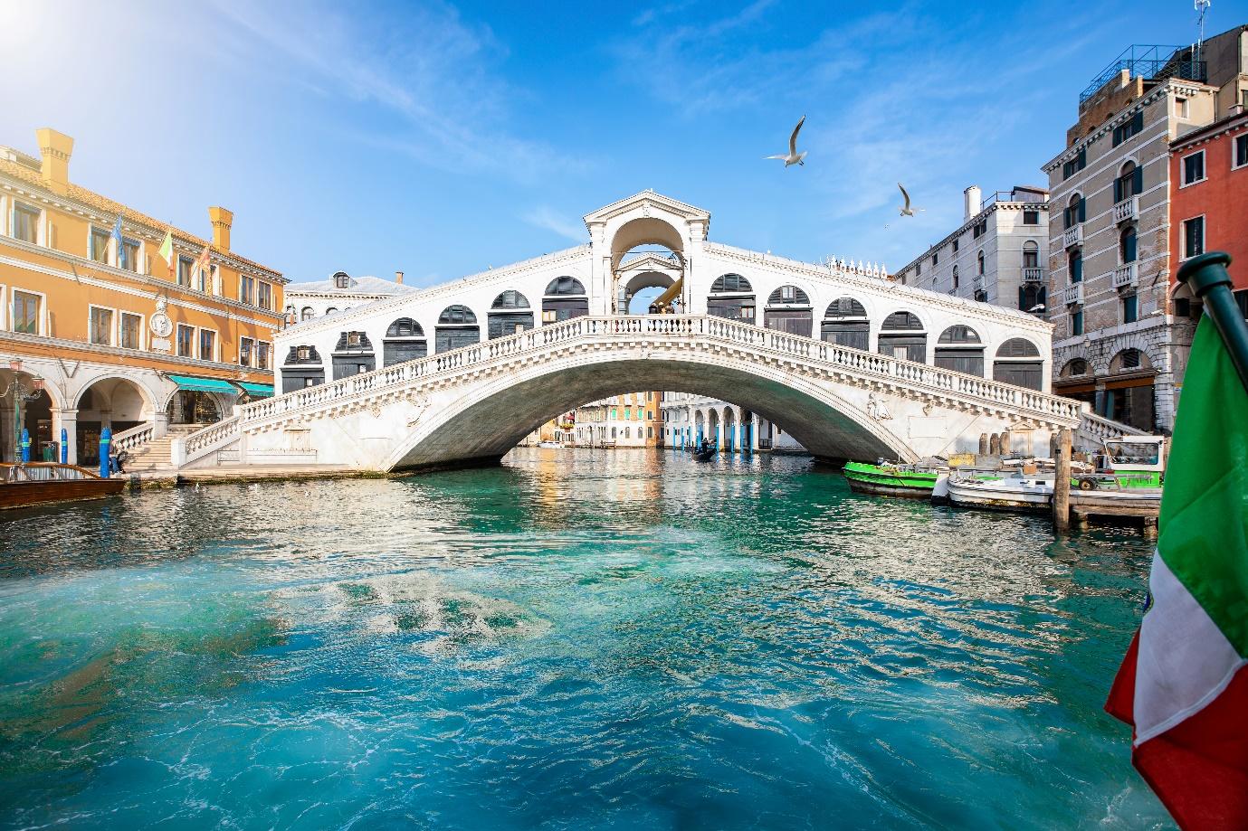 Rialto Bridge over water with boats and buildings

Description automatically generated