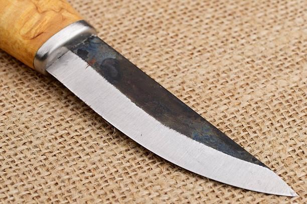 Traditional handmade Finnish knife over an old sack background. Traditional handmade Finnish knife with the wooden handle over an old sack background. Steel Will Cutjack Mini knife stock pictures, royalty-free photos & images