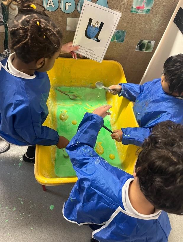 A group of children painting in a yellow tub

Description automatically generated