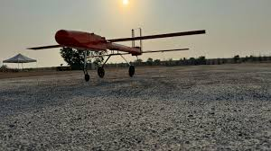 A red airplane on a gravel ground
    Description automatically generated