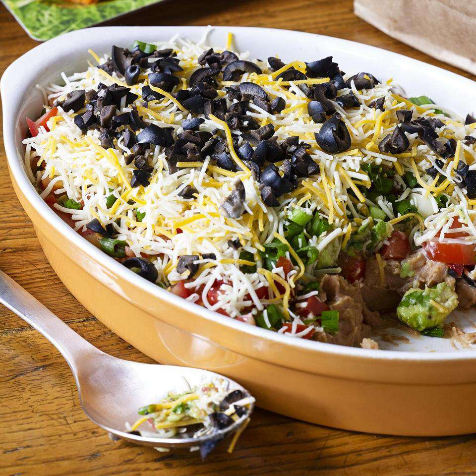 A picture of a pot full of seven layer dip, perfect for a board game party.