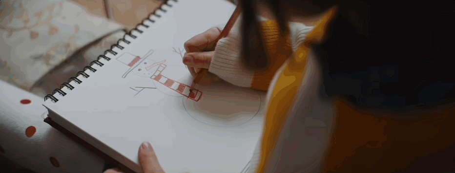A person drawing on a paper

Description automatically generated