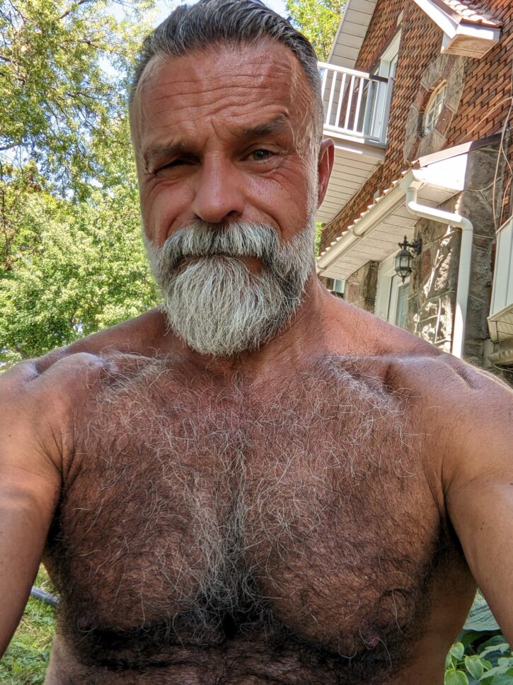 Daddy John gay xxx porn creator shirtless taking a selfie in the garden outside