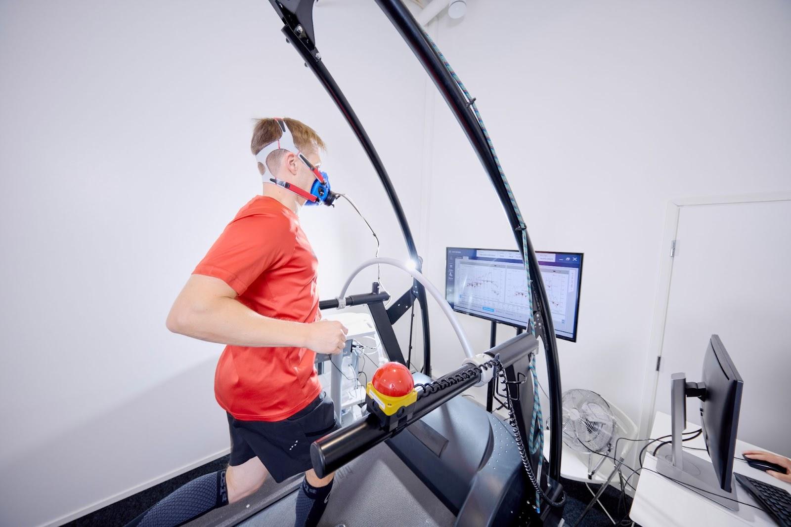 A person wearing a mask and running on a treadmill    Description automatically generated