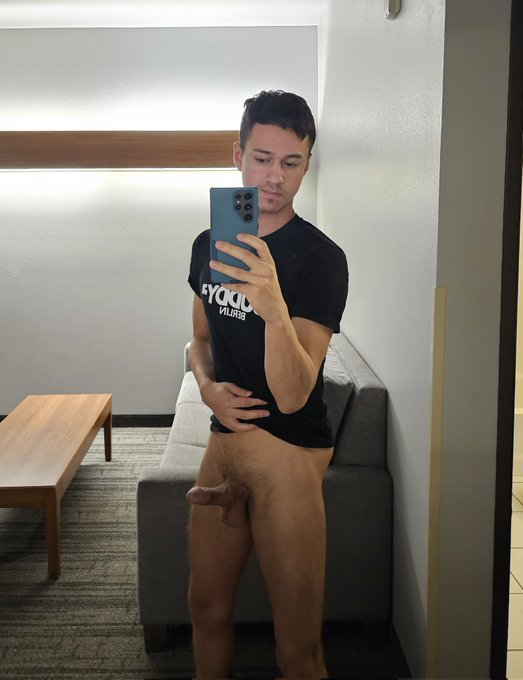 Dakota Wonders wearing no pants taking a mirror selfie showing off his cut erect cock