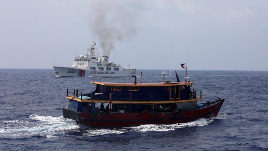A Philippine supply boat sails near a Chinese Coast Guard ship during a resupply mission for Filipino troops stationed at a grounded warship in the South China Sea, October 4, 2023.