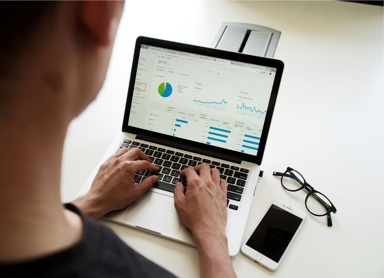 A person working on a laptop with a graph displayed on the screen.