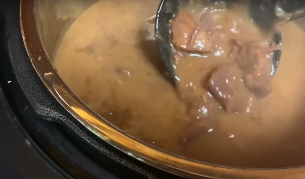 Venison gravy close up with a black spoon