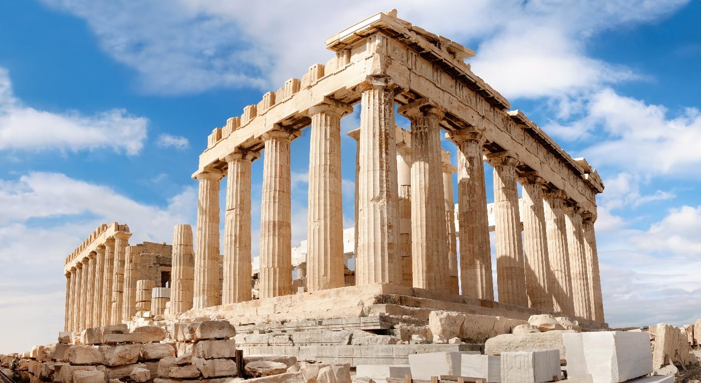 A stone structure with columns with Parthenon in the background

Description automatically generated