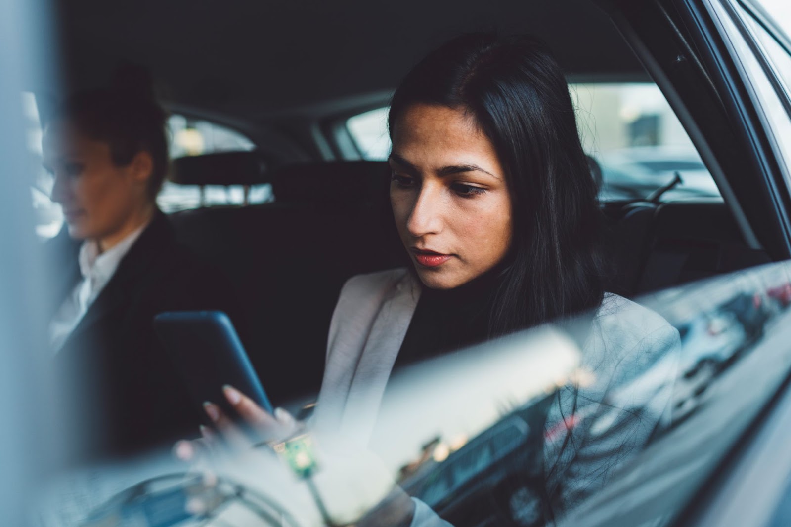 Two female passengers seated in the back of an Uber, reflecting potential clients in rideshare litigation.