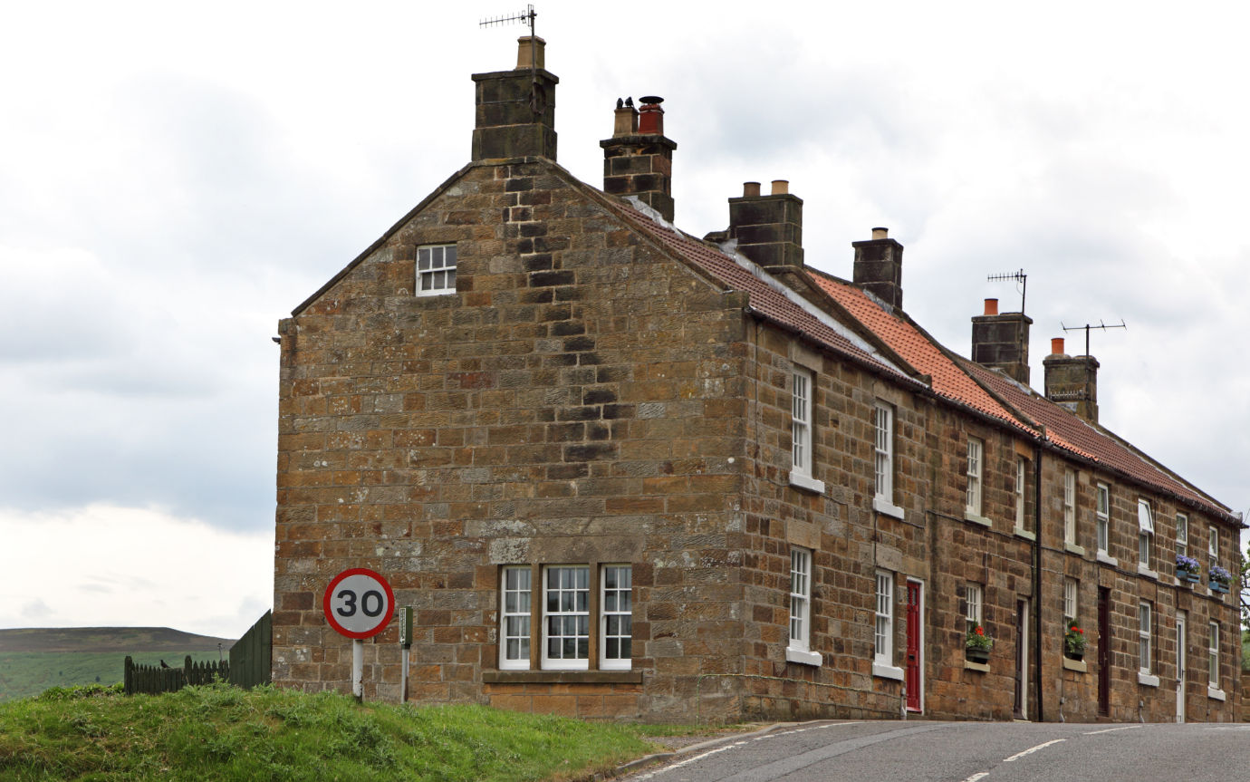 A brick building with a sign in front of itDescription automatically generated with medium confidence