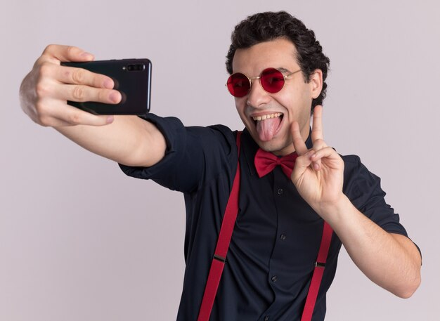 A man taking a fun selfie with his tongue out.