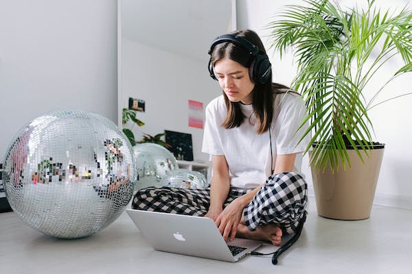 A woman using a laptop with headphones on