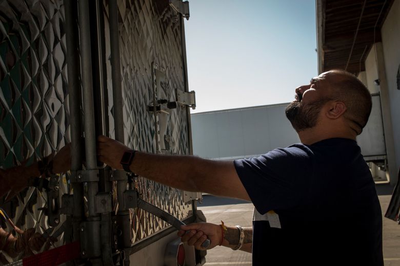 Truck driver Amit Sekhri locks the door of his trailer after securing a load in Patterson, California. Sekhri, 30, serves as a dispatcher for four drivers who deliver orders through Convoy, traditional job boards and occasionally Uber Freight. 
(David Paul Morris / Bloomberg).