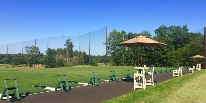 Driving range with umbrella stands
