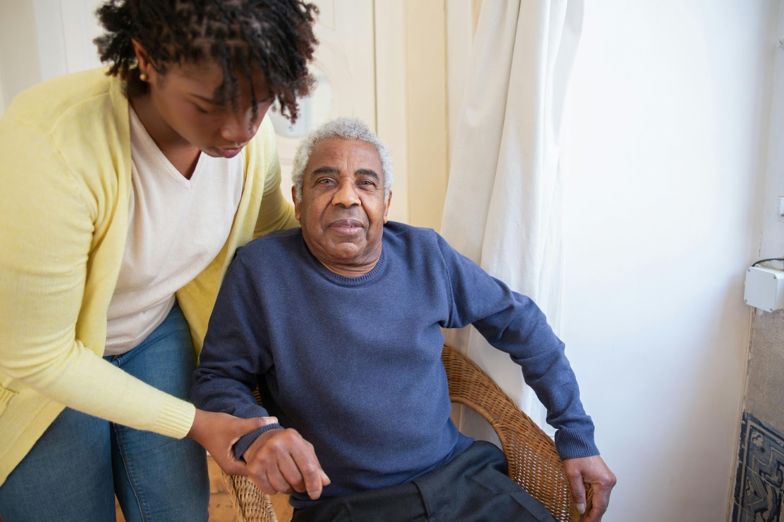 A caregiver helping a senior citizen stand up