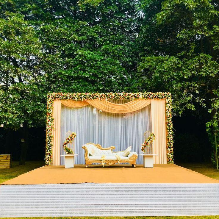 A stage with a couch and flowers

Description automatically generated