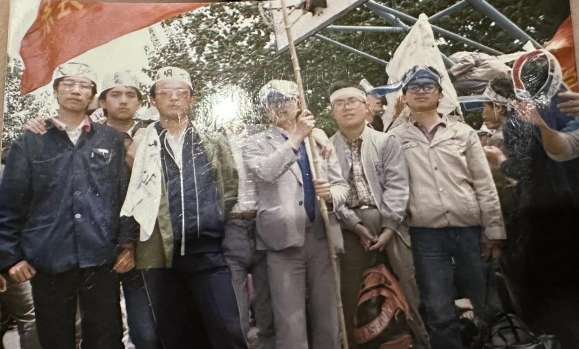 A group of men standing under a tent

Description automatically generated