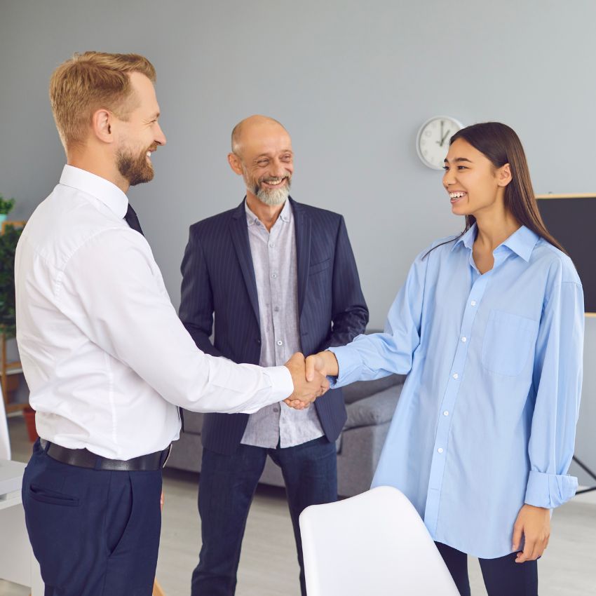 a new employee is shaking a hand with her manager