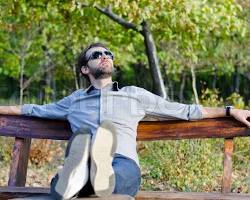 person sitting on a park bench, looking relaxed