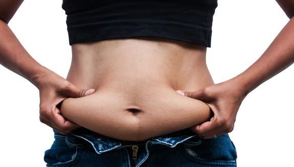 A person holding her belly

Description automatically generated