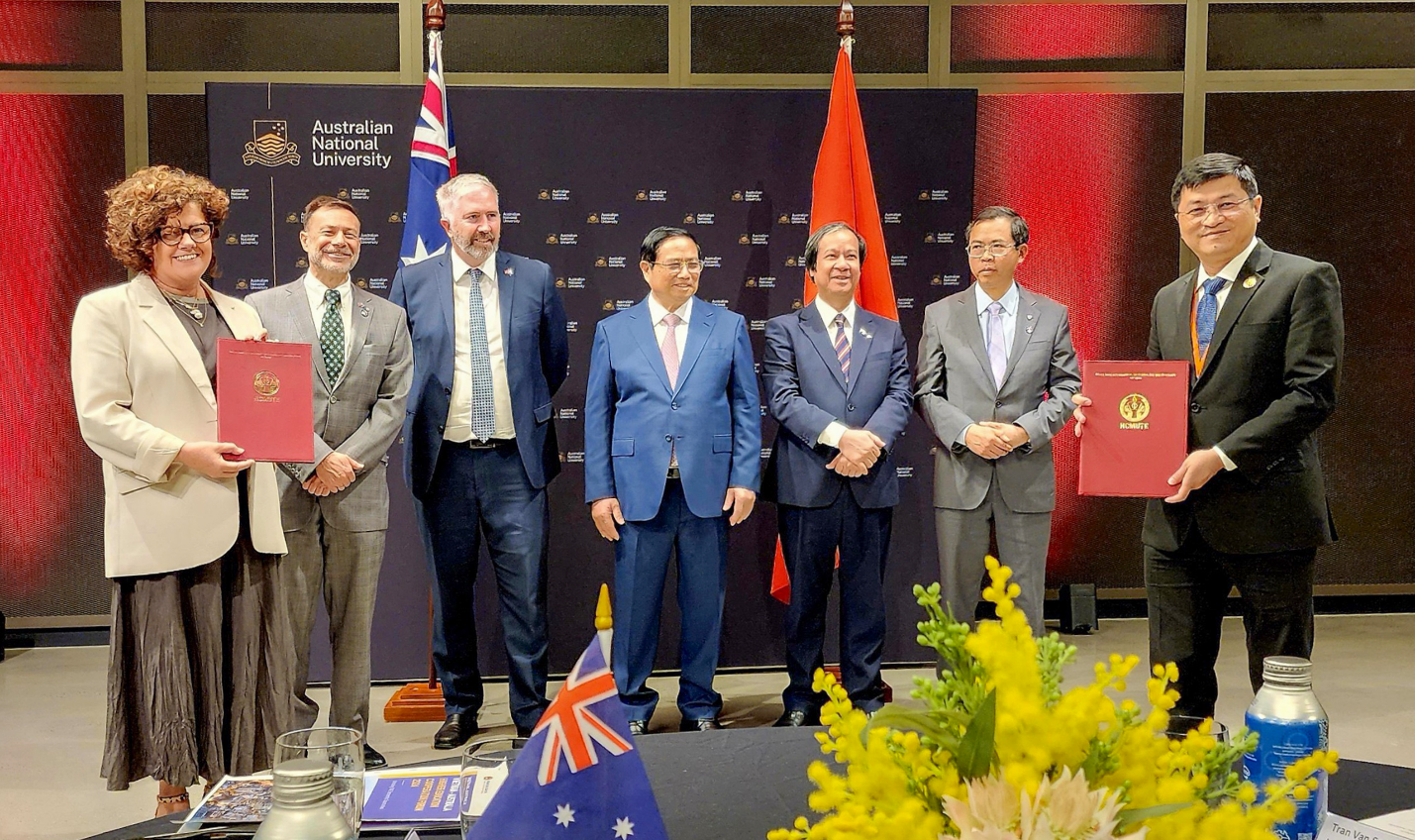 A group of men standing in front of flags
Description automatically generated