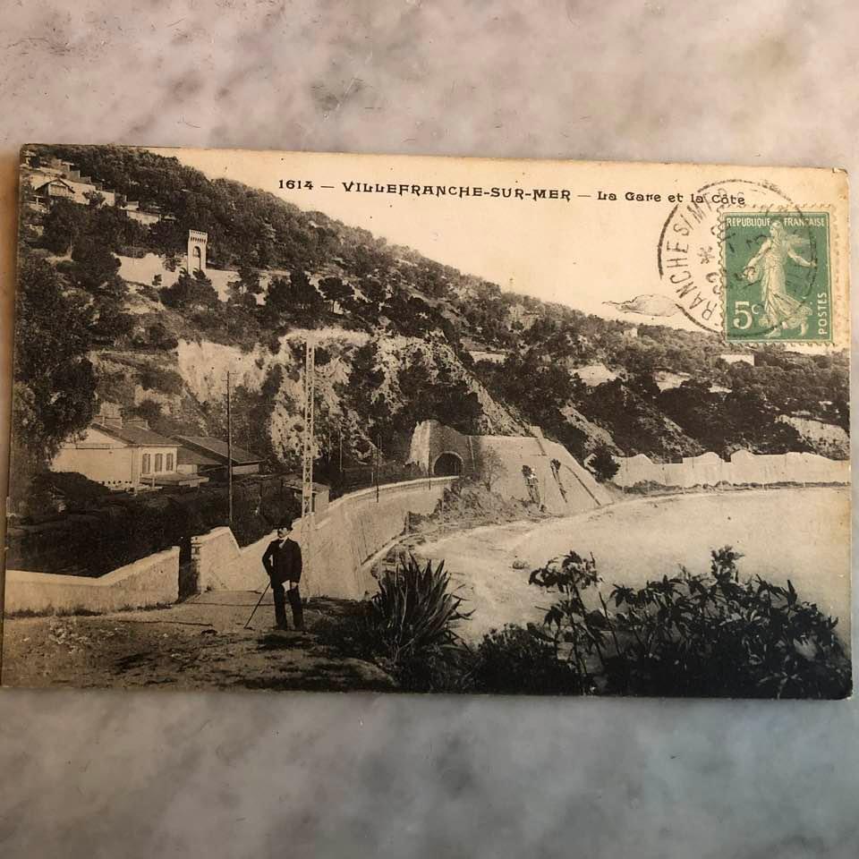 A postcard with a person standing on a hill

Description automatically generated