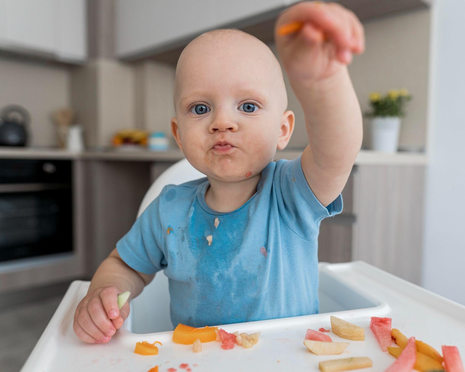bebê comendo fruta com o movimento de pinça