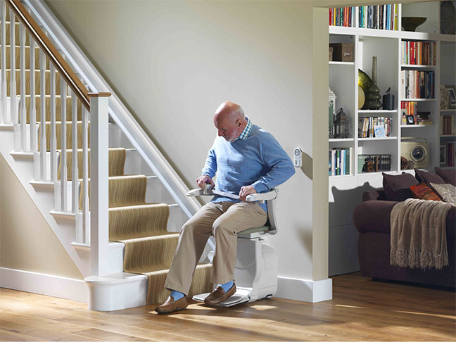 A gentleman using a straight Stannah stairlift