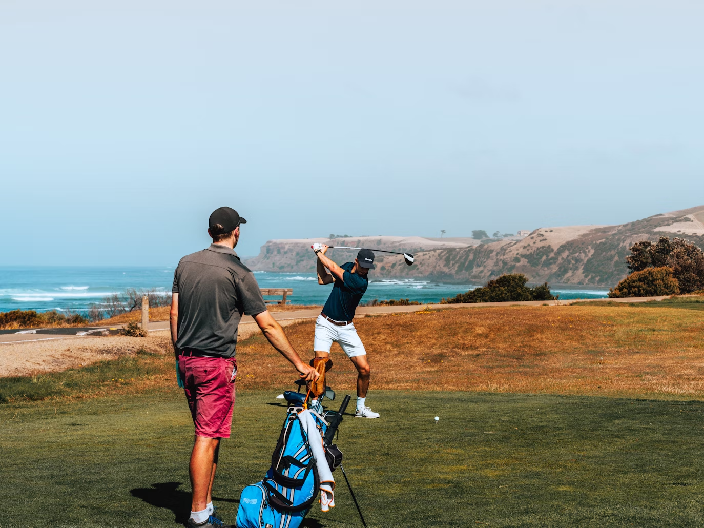 The picture shows two friends practicing Golfing.