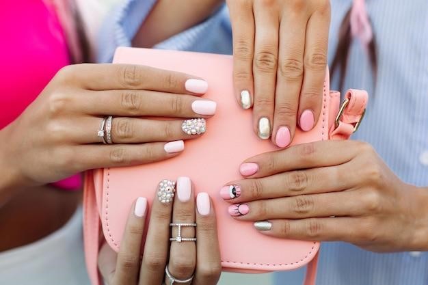 Close up of bag with girls hands with manicure over it.