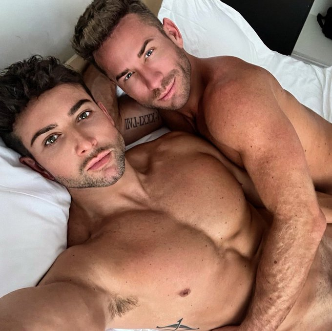 sumner blayne and koaty smling and posing on the bed for a sneak peek at their onlyfans content