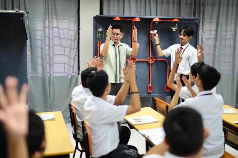 A group of people clapping in a classroom

Description automatically generated