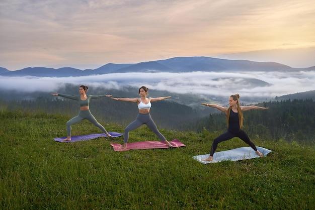 Sporty women doing yoga exercises on nature
