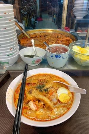 A bowl of Laksa on a countertop.
