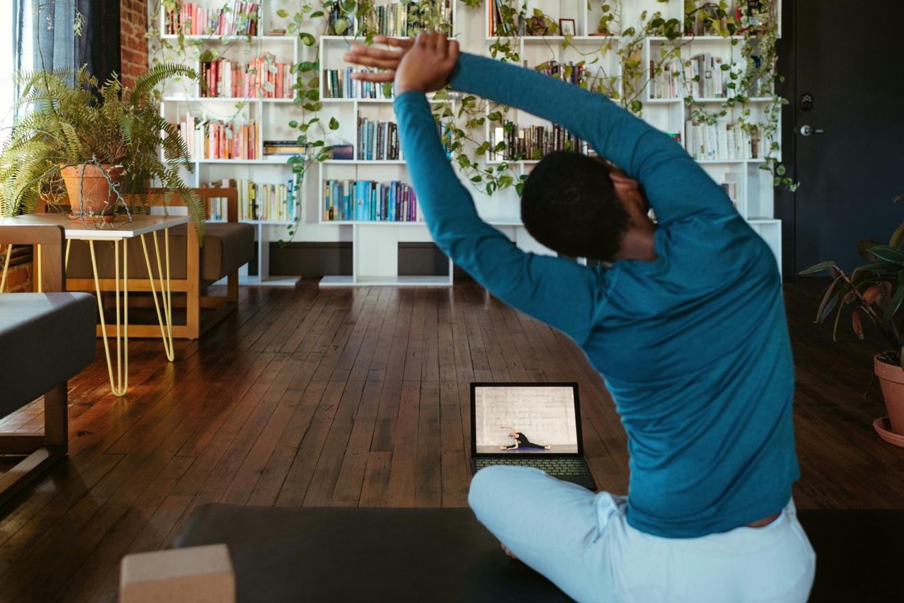 A person stretching in front of a computer

Description automatically generated