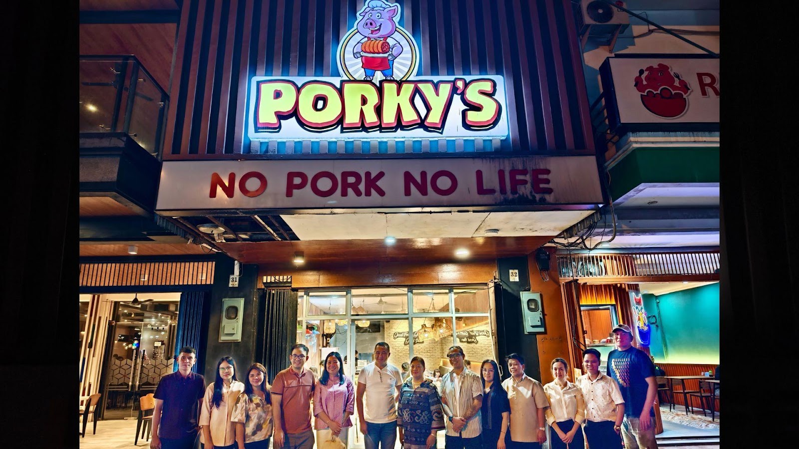 A group of people standing in front of a restaurantDescription automatically generated