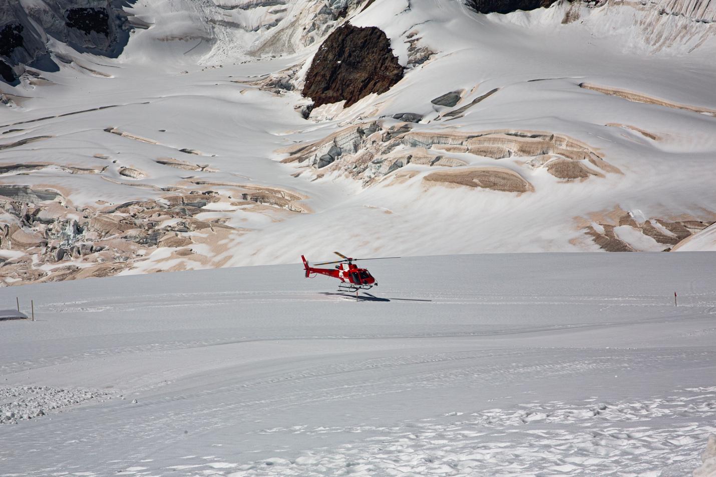 A helicopter landing on a snowy mountain

Description automatically generated