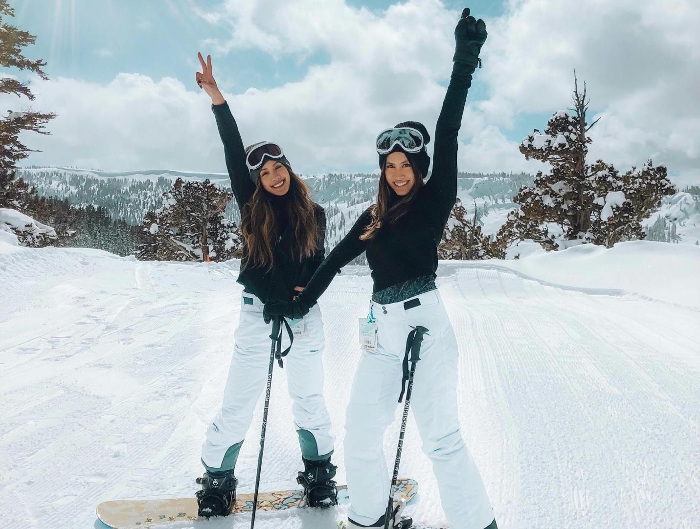 Two women on snowboards posing for the camera

Description automatically generated