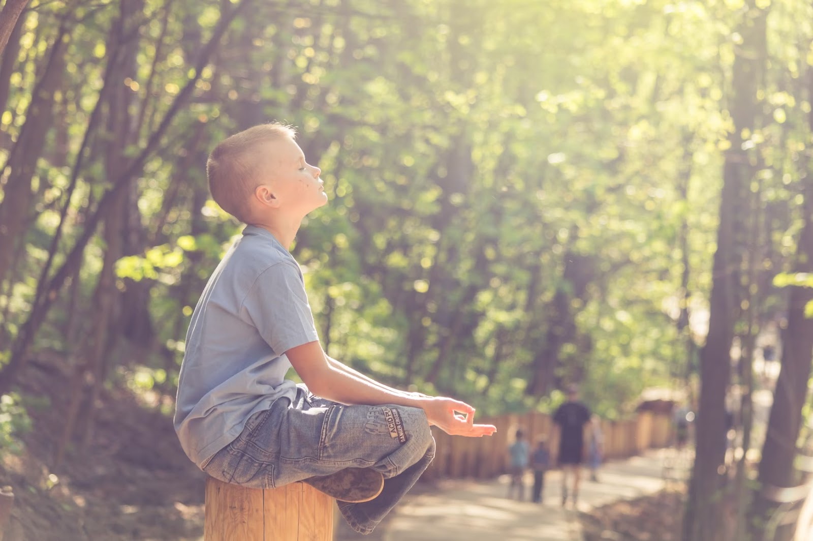 Boy meditating with his face turned up to the sun - Outdoor Exercise