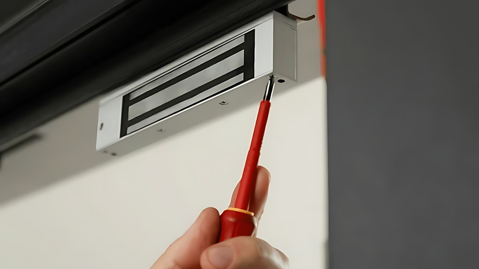 Installing a magnetic lock system at the top of a door frame